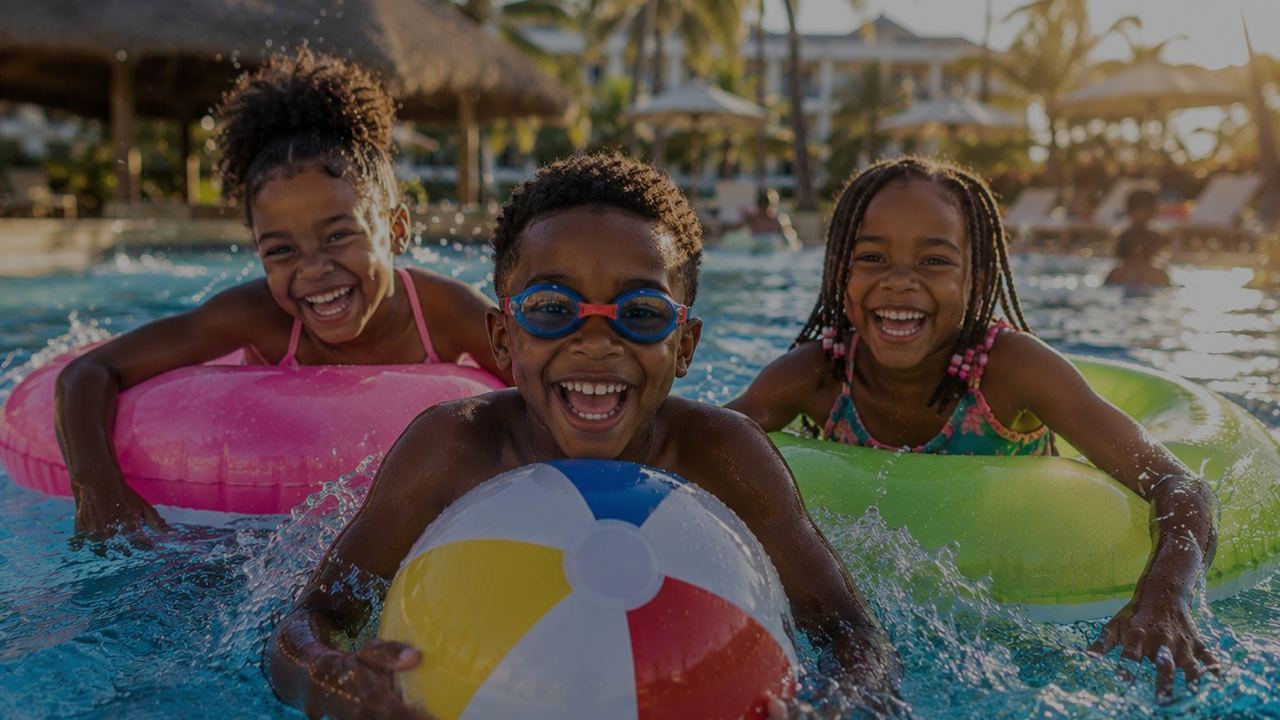 Children playing in a resort pool at golden hour